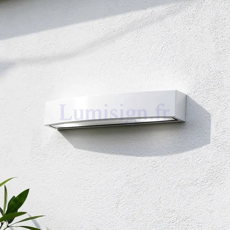 Applique murale extérieure Andromeda blanche LED IP44 fixée sur mur blanc, design épuré, éclairage haut et bas.