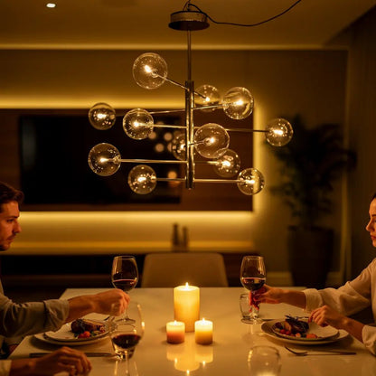 Suspension moderne EQUINOXE à douze verres transparents au centre d’une table avec bougies