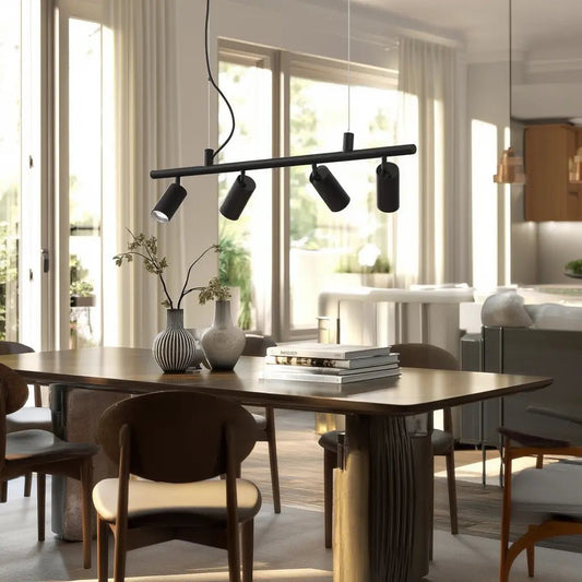 Suspension DYNAMITE SP4 noire au-dessus d’une table en bois dans une salle à manger lumineuse et moderne.