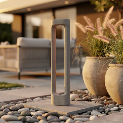 Borne extérieure lumineuse TOTEM-611 3000K en béton au design durable en situation dans une allée de jardin
