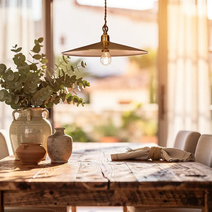 Suspension CANTINA bronze au-dessus d'une grande table en bois rustic, vase et poteries sur la table