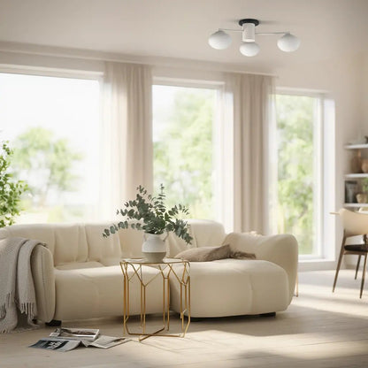 Plafonnier Hermes à 3 lampes blanc, installé au centre d’un salon lumineux avec canapé crème et table d’appoint dorée.