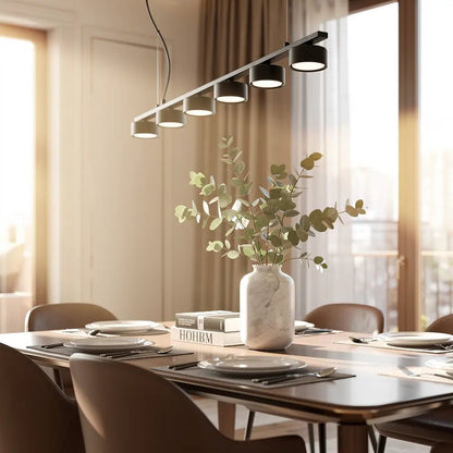 Suspension MINOR LINEAR noire à 6 spots au-dessus d’une table de salle à manger, vase marbre